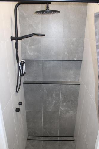 a shower with a glass door in a bathroom at Barrakee Ski Lodge in Perisher Valley