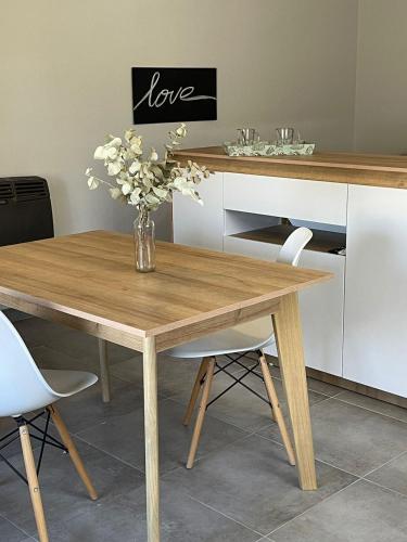 a wooden table with a vase of flowers on it at 3H MALARGUE Monoambiente in Malargüe