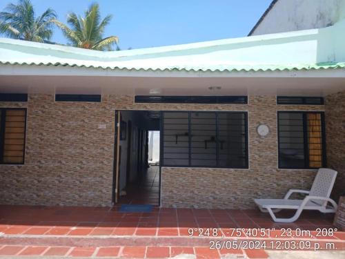 a brick house with a white chair in front of it at Juva Hostel - Coveñas in Coveñas