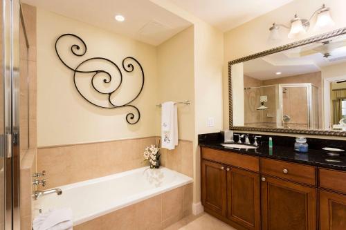 een badkamer met een bad, een wastafel en een spiegel bij Serenity Apt - Tranquil and Cozy Orlando Apartment in Kissimmee