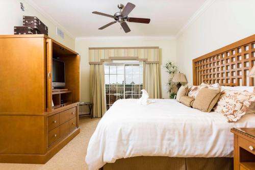 een slaapkamer met een groot bed en een plafondventilator bij Serenity Apt - Tranquil and Cozy Orlando Apartment in Kissimmee