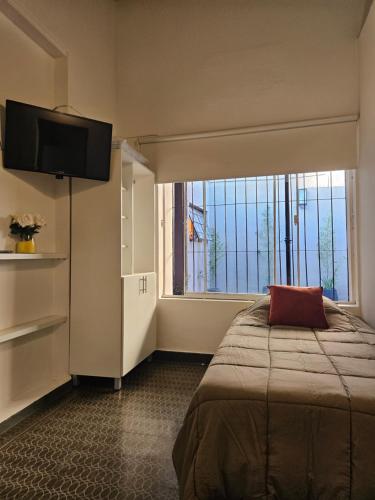 une chambre avec un lit et une grande fenêtre dans l'établissement departamentos temporarios corrientes, à Corrientes