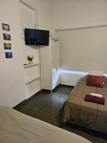 une chambre d'hôtel avec un lit et une télévision à écran plat dans l'établissement departamentos temporarios corrientes, à Corrientes