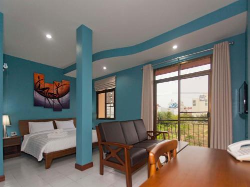 1 dormitorio con 1 cama, 1 silla y 1 ventana en Pattaya Garden Apartments Boutique Hotel, en Pattaya South