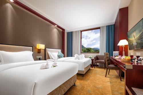 Postel nebo postele na pokoji v ubytování New Jiuzhai Hotel