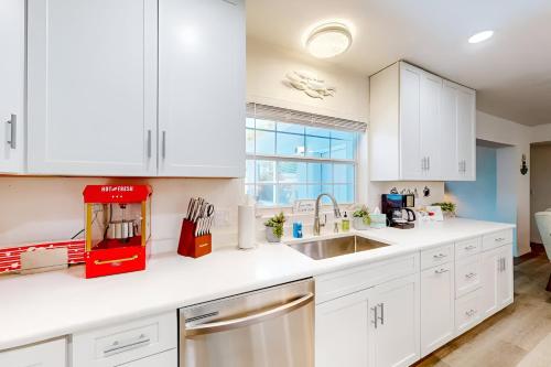 a kitchen with white cabinets and a sink at Spacious Clearwater Vacation House with Cowboy Pool Pet Friendly Fire Pit Life size Games Close to Clearwater Beach Biking Trail Farmers Markets S Harbor Health Spa Baycare Ballpark and Ruth Eckerd Hall Golf Courses in Clearwater