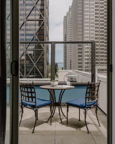 a table and chairs on a balcony with a view at Club Quarters Hotel Embarcadero, San Francisco in San Francisco