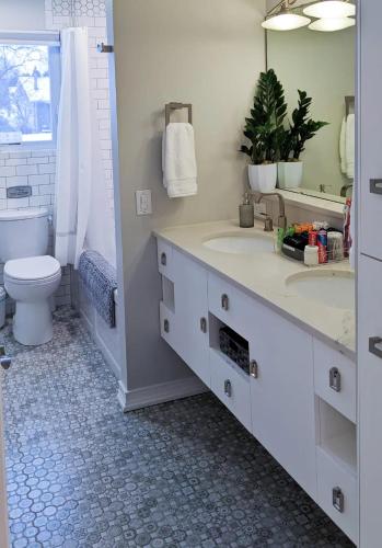 a bathroom with two sinks and a toilet and a mirror at Spacious and Elegant Space with Premium Kitchen that is Ideal for Gathering with Friends and Family in Middleton