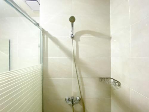 a shower with a shower head in a bathroom at Exclusive and Comfortable 1BR Apartment Mustika Golf Residence By Travelio in Cikarang