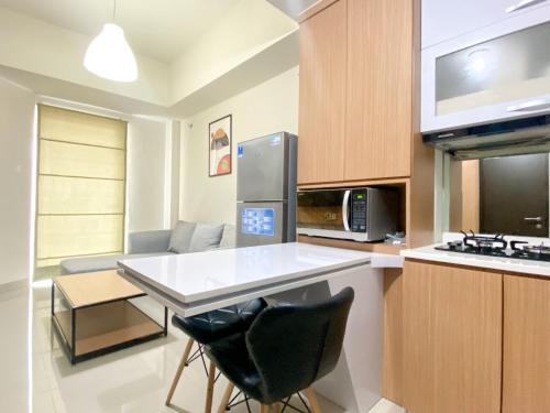 a kitchen with a white counter top and a stove top oven at Exclusive and Comfortable 1BR Apartment Mustika Golf Residence By Travelio in Cikarang