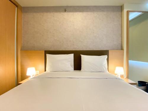 a bedroom with a large bed with two white pillows at Exclusive and Comfortable 1BR Apartment Mustika Golf Residence By Travelio in Cikarang