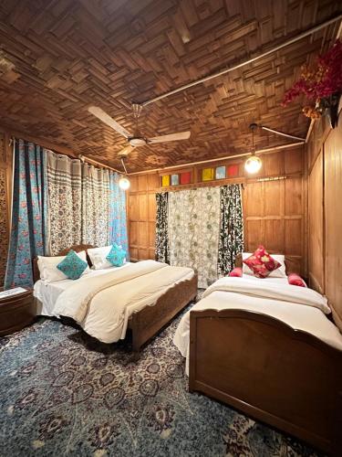two beds in a room with wooden walls at Lake Palace Group Of House Boats in Srinagar