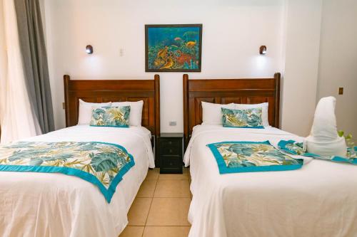 two beds sitting next to each other in a room at Hotel San Bada Resort & Spa in Manuel Antonio