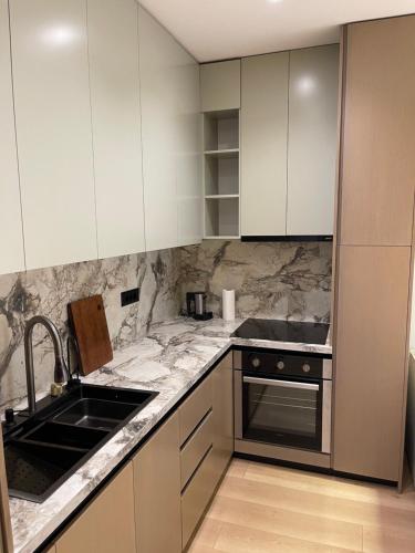 a kitchen with marble counter tops and white cabinets at Tirana Elite Apartments in Tirana