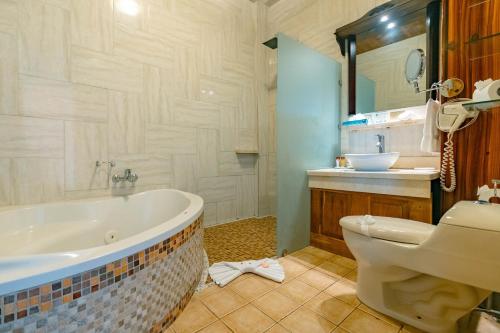 a bathroom with a tub and a toilet and a sink at Hotel San Bada Resort & Spa in Manuel Antonio