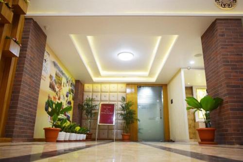 a lobby with a hallway with plants and a door at Hotel Royal Palace in Bishnāth