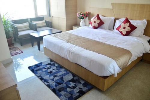 a bedroom with a large bed and a living room at Hotel Royal Palace in Bishnāth