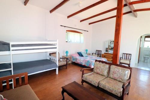 - un salon avec 2 lits superposés et un canapé dans l'établissement Naude House In Struisbaai, à Struisbaai