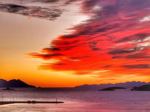 a sunset over the ocean with a boat in the water at Summer Park Residence Peljesac in Orebić