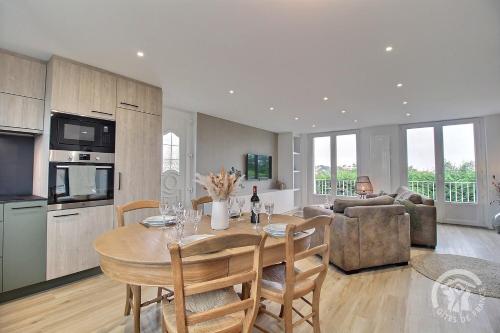 une cuisine et un salon avec une table et des chaises dans l'établissement Yemanja, à Erquy