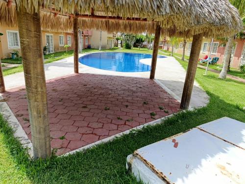 un complexe avec une piscine et un parasol dans l'établissement Casa Victor Manuel, à La Sabana