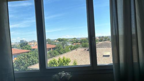 une fenêtre avec vue sur la ville dans l'établissement Joli T2 Métro la vache, à Toulouse
