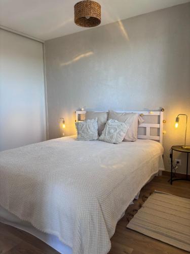 une chambre avec un grand lit blanc avec deux oreillers dans l'établissement Joli T2 Métro la vache, à Toulouse