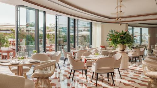 a restaurant with tables and chairs and windows at Jumeirah Residences Marsa Al Arab Dubai in Dubai