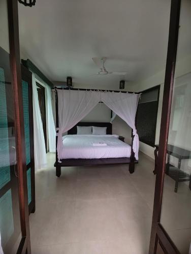 a bedroom with a bed with a canopy at Shivam bnb Boutique Apartments in Mandrem