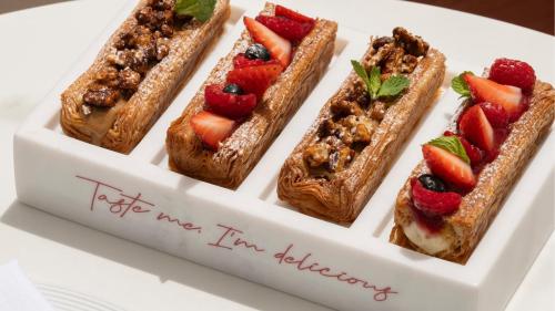 ein weißer Teller mit vier Gebäckstücken mit Früchten darauf in der Unterkunft Jumeirah Residences Marsa Al Arab Dubai in Dubai