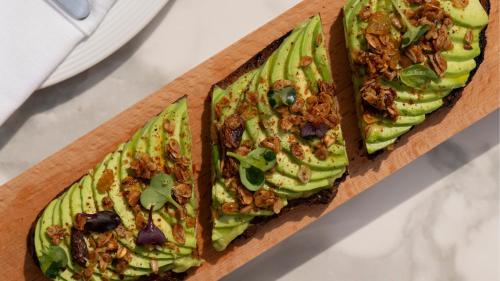 ein hölzernes Schneidebrett mit drei Avocadoscheiben darauf in der Unterkunft Jumeirah Residences Marsa Al Arab Dubai in Dubai