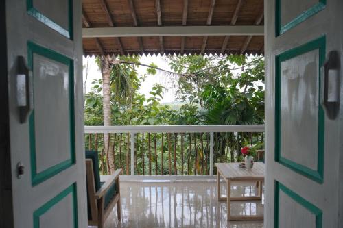 an open door to a porch with a table and a table at Purwa Ijen in Banyuwangi