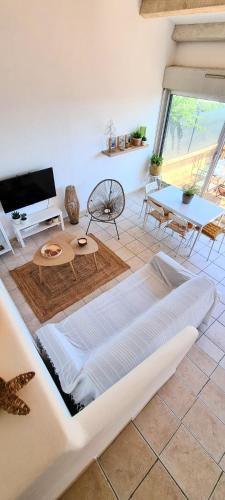 un salon avec un canapé blanc et une table dans l'établissement Villa vue mer incroyable ! Face aux calanques, à Sausset-les-Pins