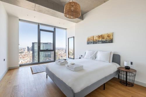 a white bedroom with a large bed and large windows at Beautiful Bright Deluxe 1bd Condo Poolviews! #311 in Istanbul