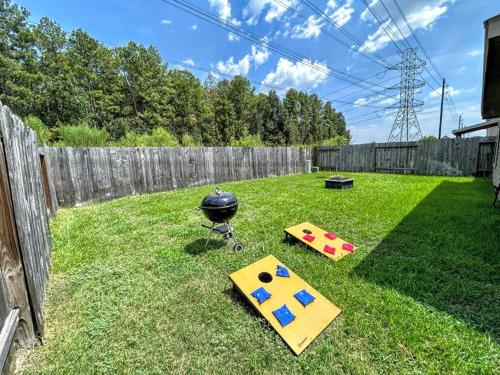 a backyard with a bbq and a grill on the grass at Cozy Getaway Nr Airport WiFi BBQ Yard Pet in Humble