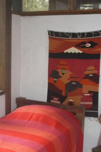 a bedroom with a bed with a colorful pillow at Lodge France Amazonia in Puerto Misahuallí