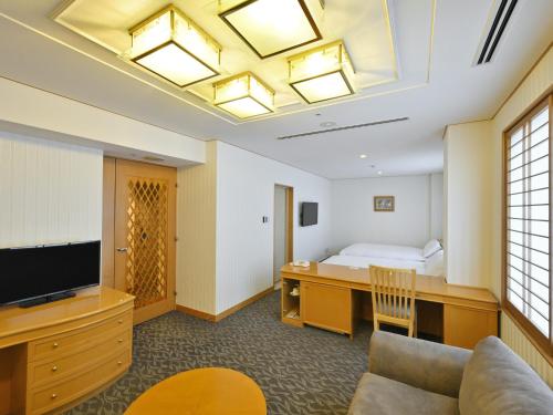 a hotel room with a bed and a television at Rihga Hotel Zest Takamatsu in Takamatsu