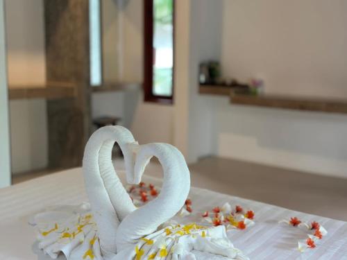 two white swans forming a heart on a table at Ibiza Bungalows in Haad Yao