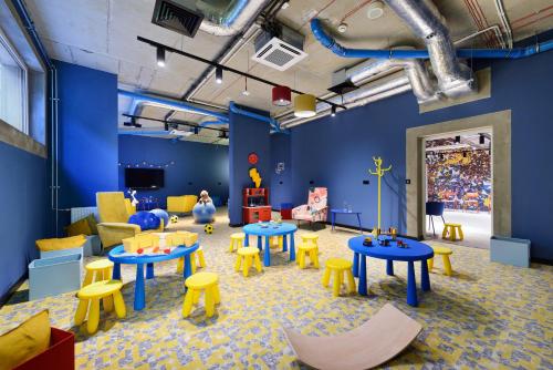 a childrens room with tables and yellow chairs at Arche Nałęczów & SPA dawne Sanatorium Milicyjne in Nałęczów