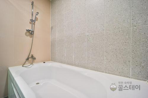 a bath tub with a shower in a bathroom at Brown Dot Hotel Guun in Suwon