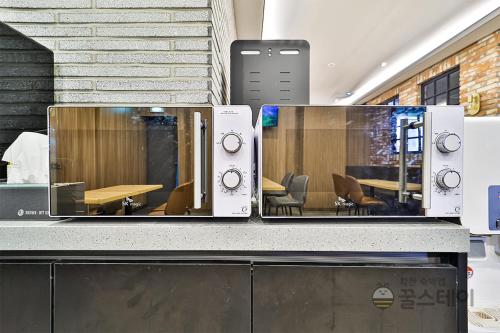 a counter with twowindows with a table in a room at Brown Dot Hotel Guun in Suwon