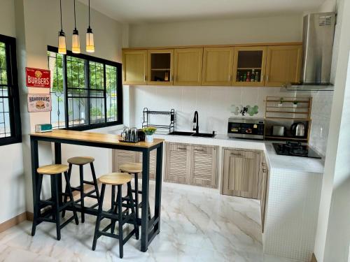 a kitchen with a island with bar stools in it at SwanBB in Hang Dong