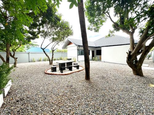 a park with a bench and trees in front of a building at SwanBB in Hang Dong