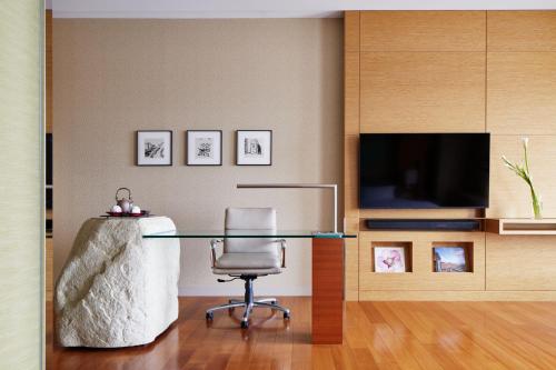 a glass table with a chair and a television at InterContinental Hotel Osaka by IHG in Osaka