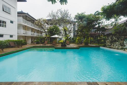 a large blue swimming pool next to a building at Hotel Sari Bunga in Legian