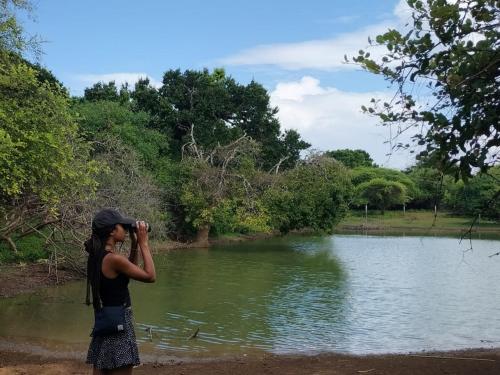 a woman taking a picture of a river at Yala Ying Yang Hostel & Camping in Yala