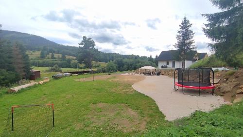 a park with a playground with a swing at Chalúpky pod Viaduktom in Telgárt