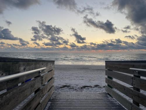 a wooden boardwalk leading to the beach at sunset at Sun, Sand, Coastal Haven 3 in Clearwater Beach