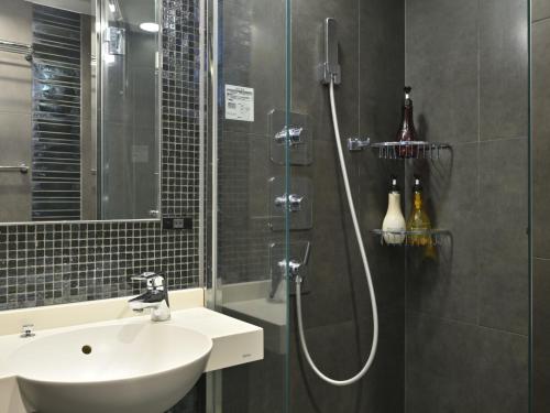 a bathroom with a shower with a sink and a shower at Rihga Hotel Zest Takamatsu in Takamatsu