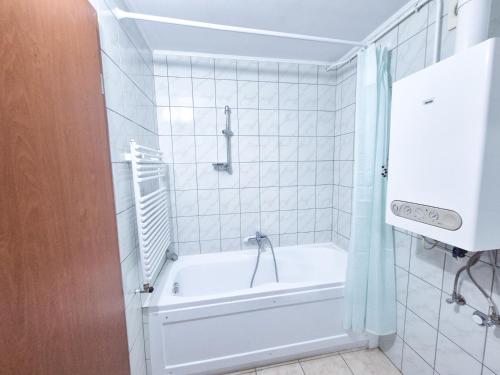biała łazienka z wanną i prysznicem w obiekcie Ildiko Apartmanhaz w Zamárdi